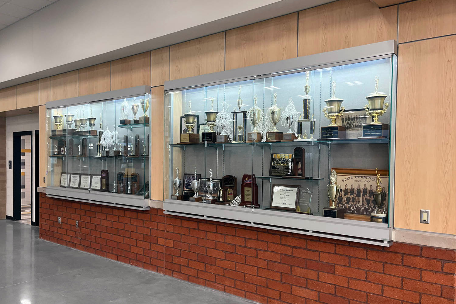 Glass display case with student sports trophies